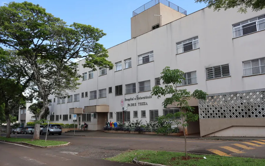 Fachada do Hospital e Maternidade Padre Tezza, prédio branco de três andares com árvores na frente, em Matelândia